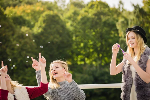 Mulheres amigas soprando bolhas de sabão . — Fotografia de Stock