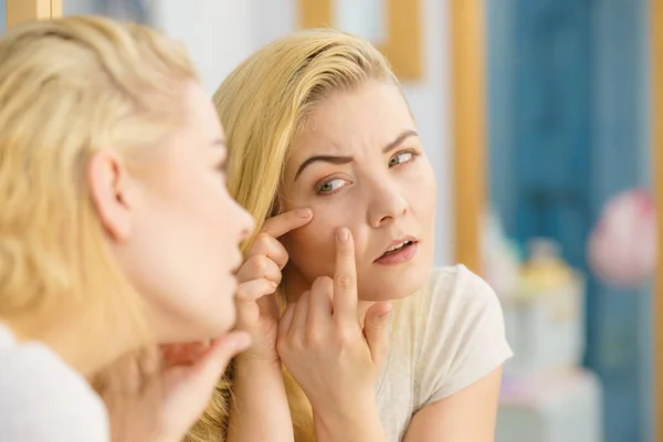 Femme regardant sa peau dans le miroir — Photo