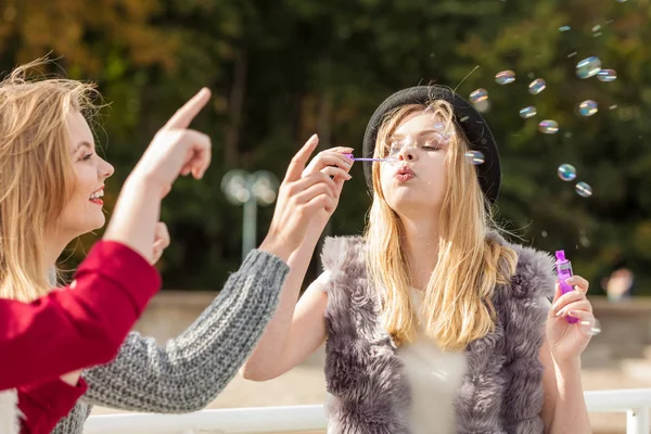 Vrouwen die samen spelen blazen zeepbellen — Stockfoto