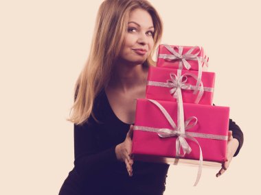 Pembe hediye kutuları yığını tutan kız