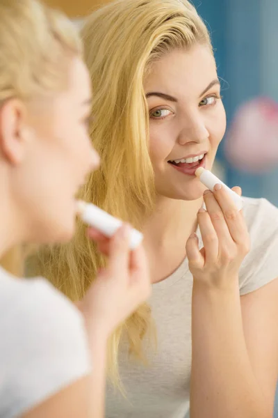 Mujer en baño aplicando bálsamo labial —  Fotos de Stock