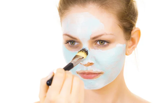 Kız yüz yeşil çamur maskesi uygulamak — Stok fotoğraf