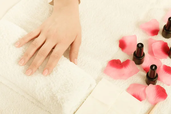 Vrouw hand op handdoek, naast manicure set — Stockfoto