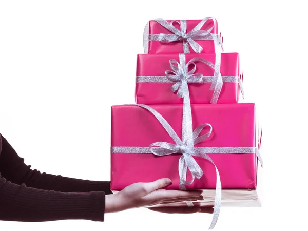 Руки женщины держат стопку розовых подарочных коробок — стоковое фото