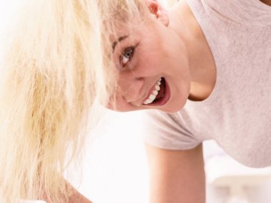 Sarı saçlarla oynayan kadın.