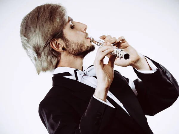 Male flutist wearing tailcoat plays flute — Stock Photo, Image