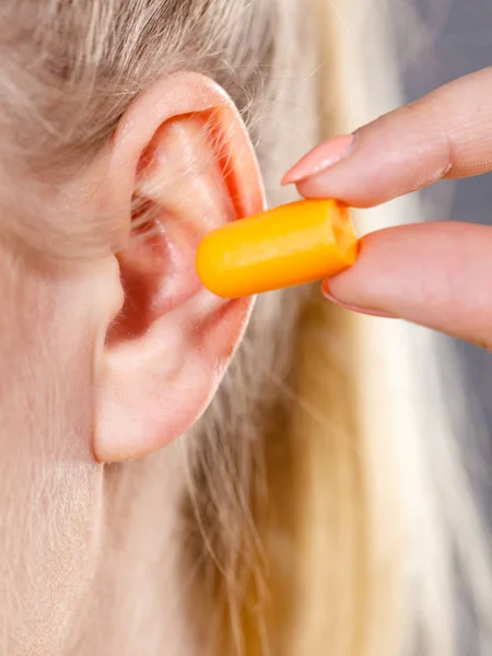 Woman putting earplugs — Stock Photo, Image