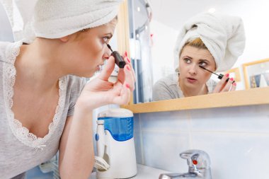 Kadın banyoda maskara kirpik üzerinde uygulama
