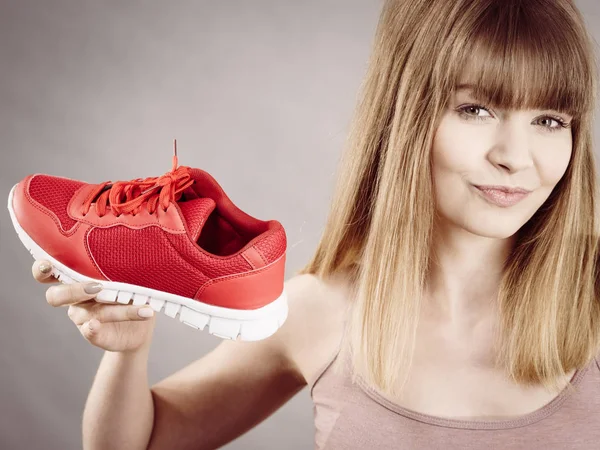 Glückliche Frau präsentiert Sportbekleidung Turnschuhe — Stockfoto