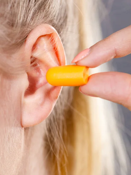 Woman putting earplugs — Stock Photo, Image