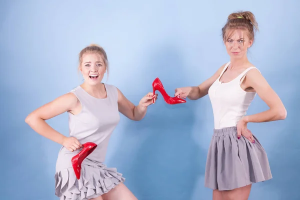 Mujeres discutiendo sobre tacones altos rojos — Foto de Stock