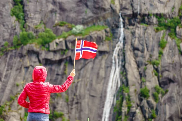Mujer turista con bandera noruega en rocas montañas — Foto de Stock