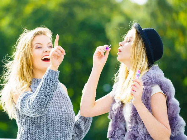 Vrouwen vrienden zeepbellen blazen. — Stockfoto