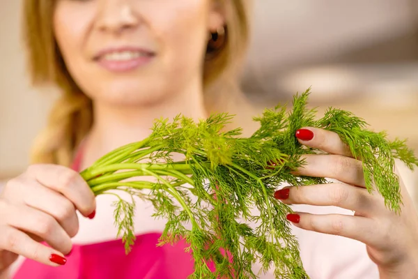 Woman holding green dill herb