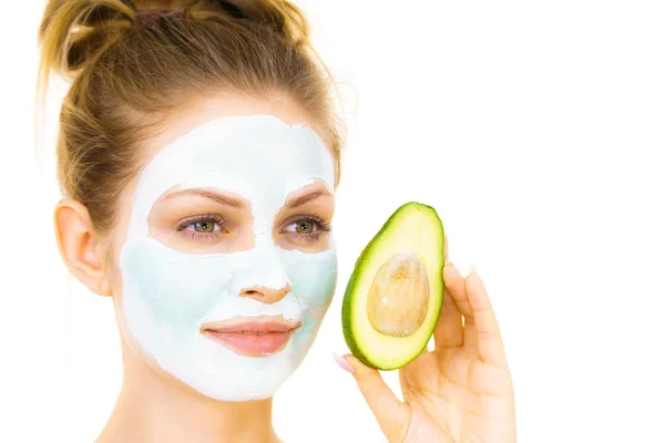 Meisje gezicht modder masker houdt avocado fruit — Stockfoto