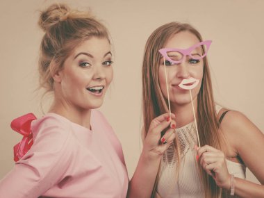 Karnaval aksesuarları tutan iki kadın