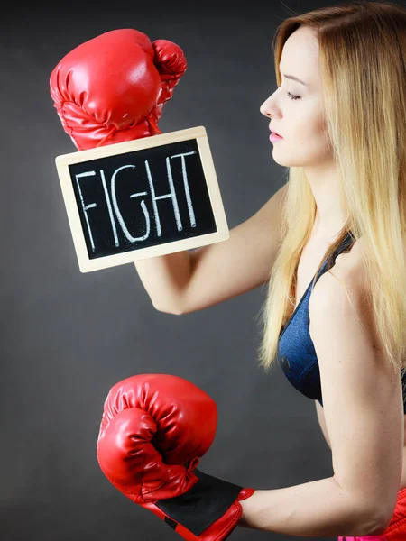 Žena nosí Boxerské rukavice drží boj znamení — Stock fotografie