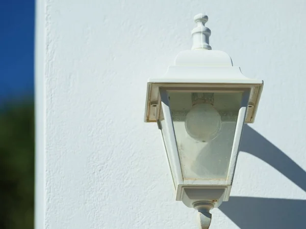 Старая лампа на коричневой белой стене — стоковое фото