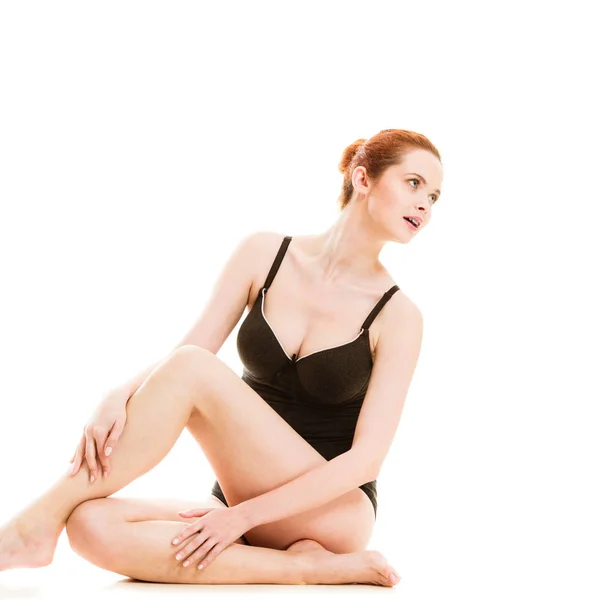 Sitzende Frau in Unterwäsche zeigt glatte Beine — Stockfoto