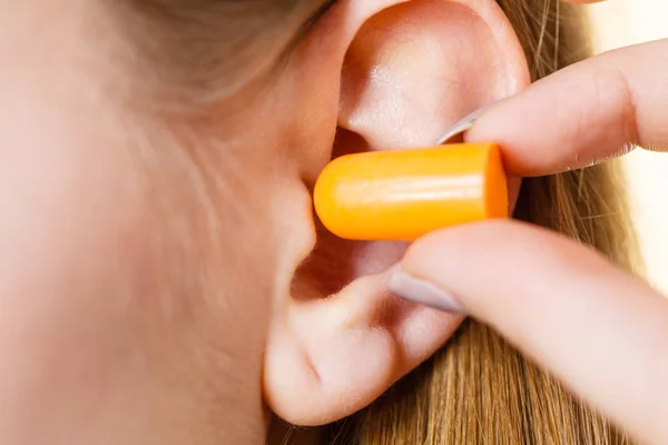 Woman putting earplugs — Stock Photo, Image