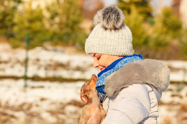 Mulher brincando com cão durante o inverno — Fotografia de Stock