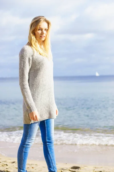 Woman in sweater walking on beach — Stock Photo, Image