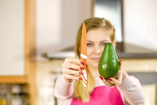 Frau schneidet Avocado — Stockfoto