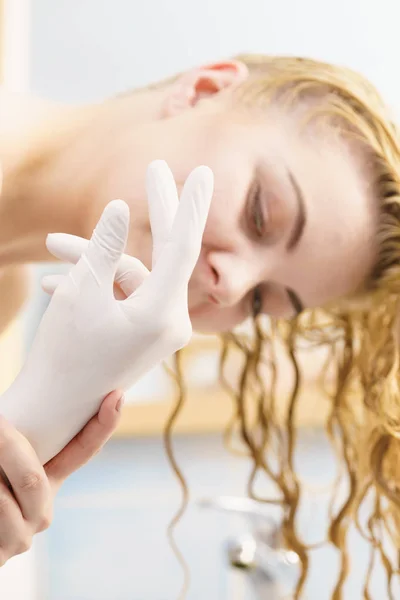 Kobieta z białe rękawiczki lateksowe w łazience — Zdjęcie stockowe