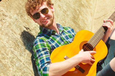 Genç hipster adam gitar ile açık sakallı.