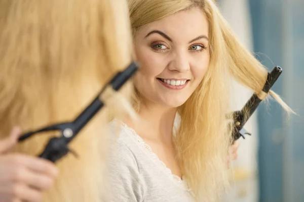 Woman using hair curler