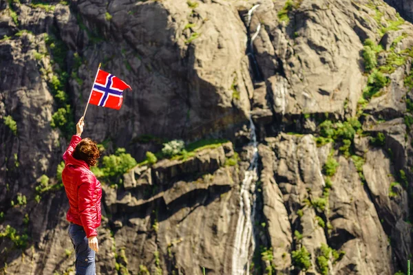 Tourist woman with norwegian flag in rocks mountains — Stock Photo, Image