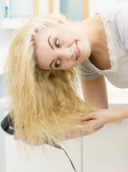 Mulher loira usando secador de cabelo — Fotografia de Stock