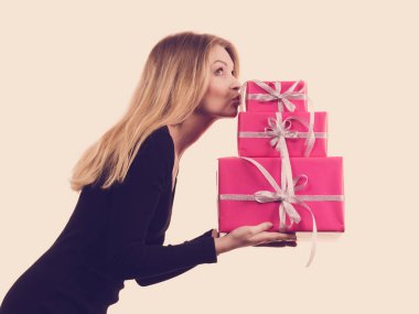 Pembe hediye kutuları yığını tutan kız
