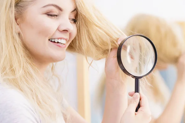 Šťastná žena hledá prostřednictvím Lupa na vlasy — Stock fotografie