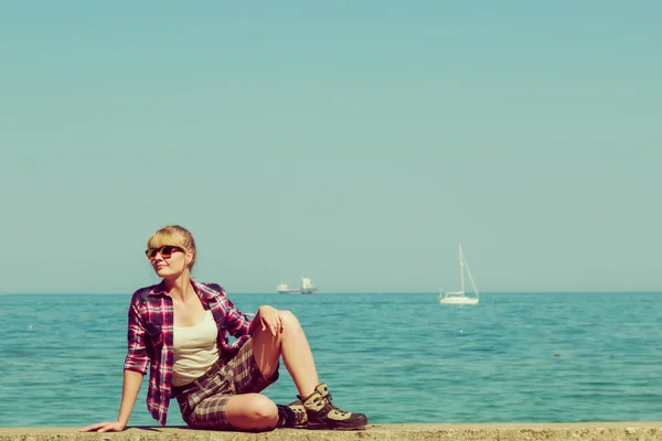 Woman hiker relaxing on sea coast — Stock Photo, Image