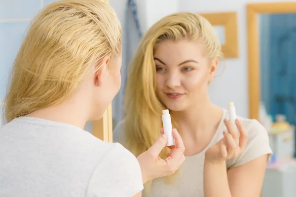 Mujer en baño aplicando bálsamo labial —  Fotos de Stock