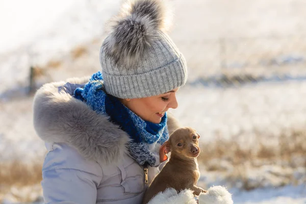 Mujer jugando con perro durante el invierno —  Fotos de Stock