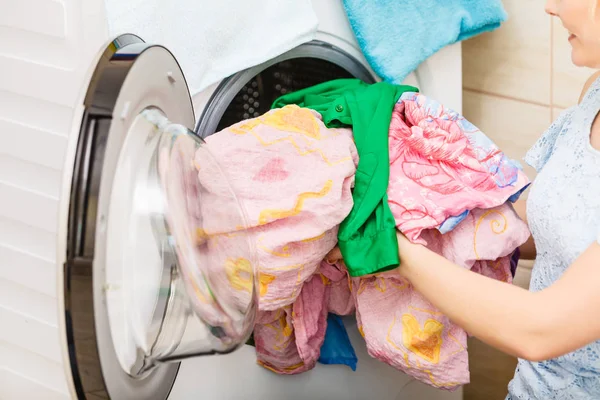 Человек кладет одежду в стиральную машину — стоковое фото
