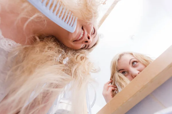 Donna spazzolando i suoi capelli biondi bagnati — Foto Stock