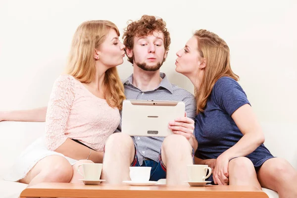 Mujeres chicas besando hombre chico con tableta. Diversión . — Foto de Stock