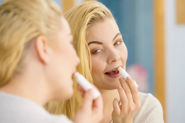 Mujer en baño aplicando bálsamo labial — Foto de Stock