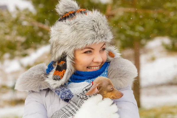 Γυναίκα αγκαλιά του πλανήτη το μικρό σκυλάκι της τον χειμώνα — Φωτογραφία Αρχείου
