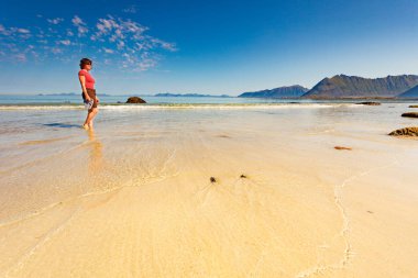 Kumsalda, Lofoten Norveç yürüyen kadın