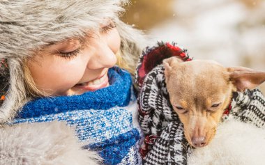 Küçük köpeğini kışın ısınma kadın kucaklama
