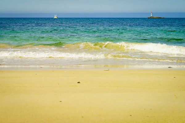 Seascape sandig strand med fyren på horisonten — Stockfoto