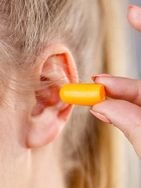 Kvinna att sätta öronproppar — Stockfoto