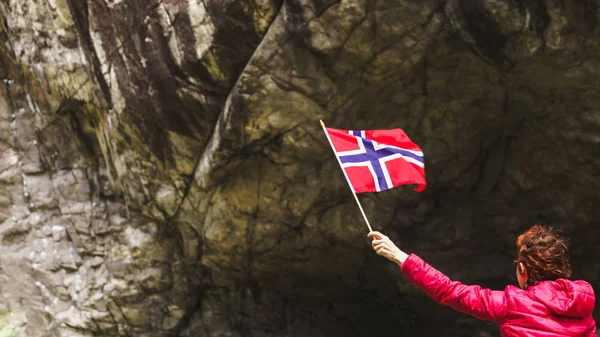 Donna turistica con bandiera norvegese nelle montagne rocciose — Foto Stock