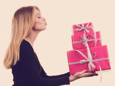 Pembe hediye kutuları yığını tutan kız