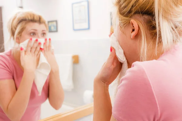 Женщина с белым полотенцем вытирает лицо после очистки — стоковое фото