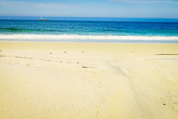 Seascape sandig strand med fyren på horisonten — Stockfoto